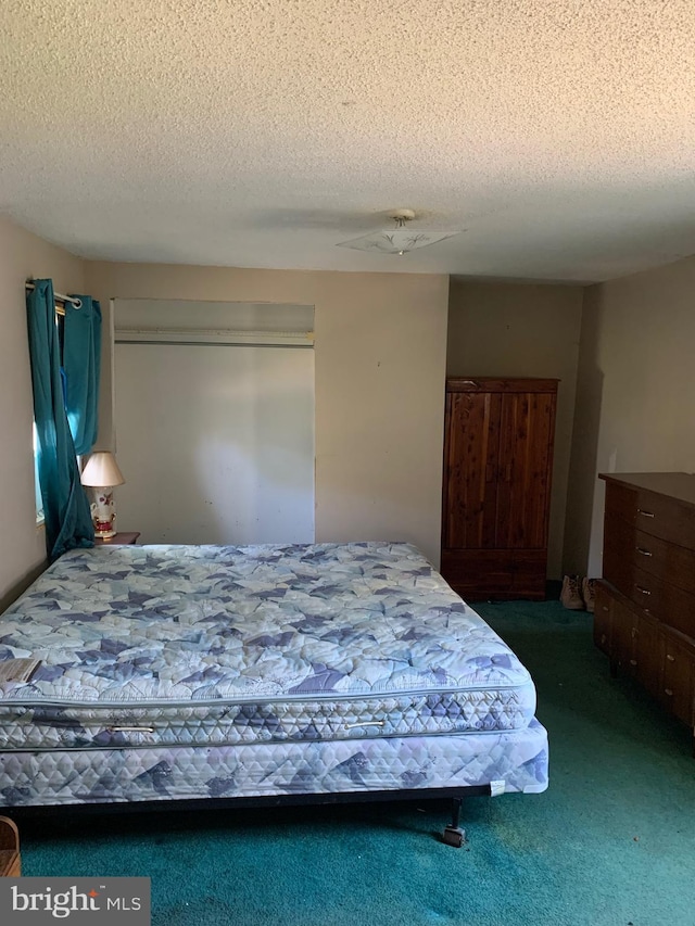 carpeted bedroom with ceiling fan and a textured ceiling