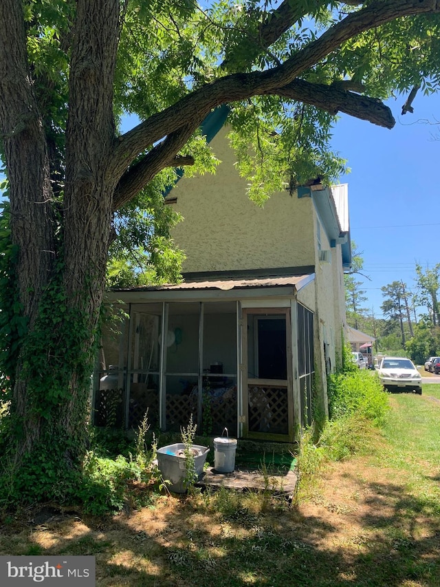 view of property exterior featuring a sunroom