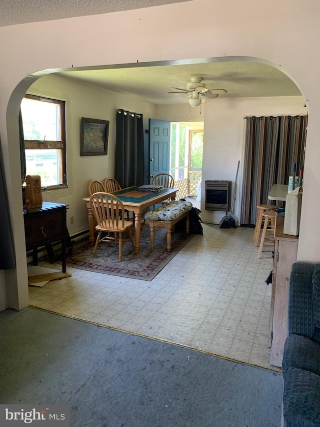 dining room with heating unit, ceiling fan, and a textured ceiling