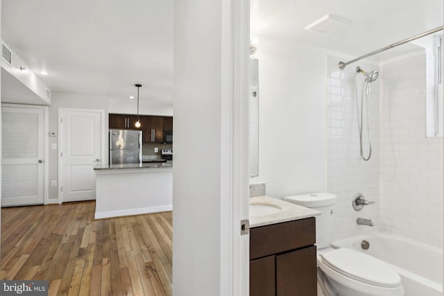 full bathroom featuring vanity, toilet, wood-type flooring, and tiled shower / bath