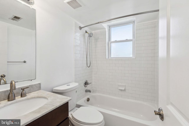 full bathroom featuring vanity, tiled shower / bath combo, and toilet