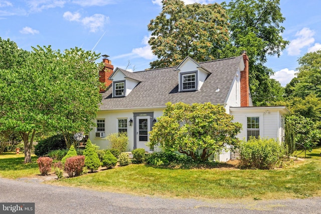 cape cod house with a front lawn