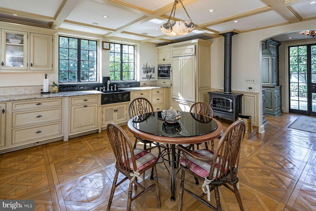 kitchen with cream cabinets, built in appliances, and a wealth of natural light