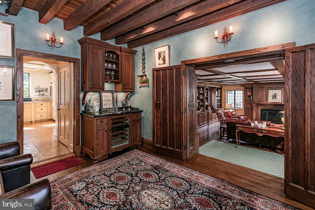 kitchen with wine cooler, dark hardwood / wood-style floors, beam ceiling, and a wealth of natural light