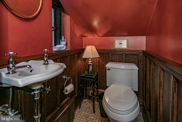 bathroom featuring sink, lofted ceiling, and toilet