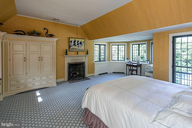 bedroom featuring light colored carpet, a fireplace, and vaulted ceiling