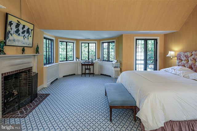 bedroom with a brick fireplace, wooden ceiling, and vaulted ceiling