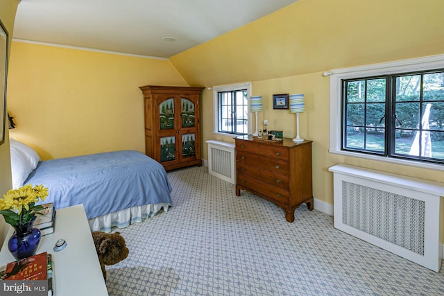 carpeted bedroom with radiator and vaulted ceiling