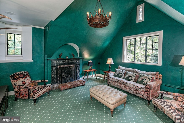 carpeted living room featuring a fireplace, plenty of natural light, vaulted ceiling, and a chandelier