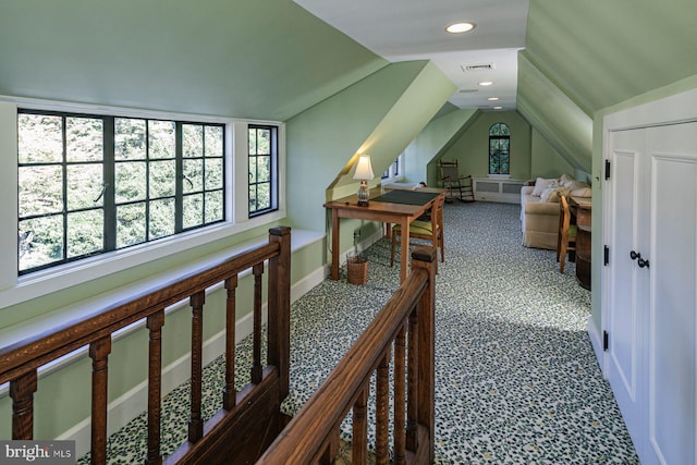 corridor with lofted ceiling and carpet floors