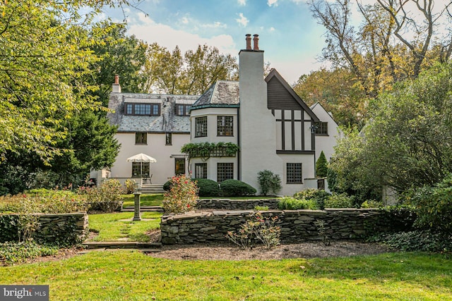 rear view of property featuring a lawn