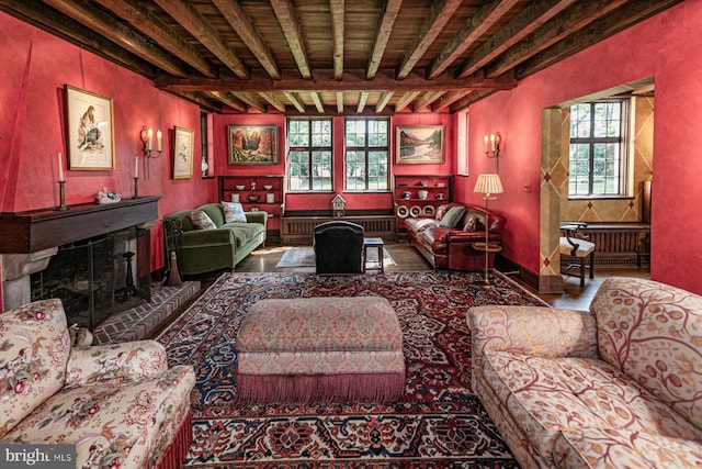 living room with a fireplace, beam ceiling, and a wealth of natural light