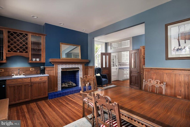 dining area with dark hardwood / wood-style flooring, sink, and a tiled fireplace