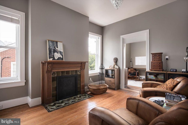 living room with light wood-type flooring and a tile fireplace