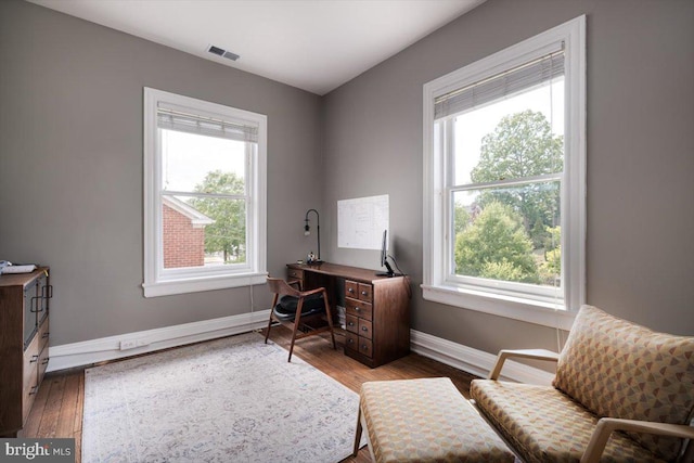 home office with plenty of natural light and hardwood / wood-style floors