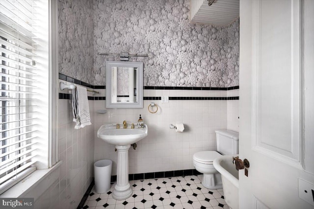 bathroom with tile patterned floors, tile walls, and toilet