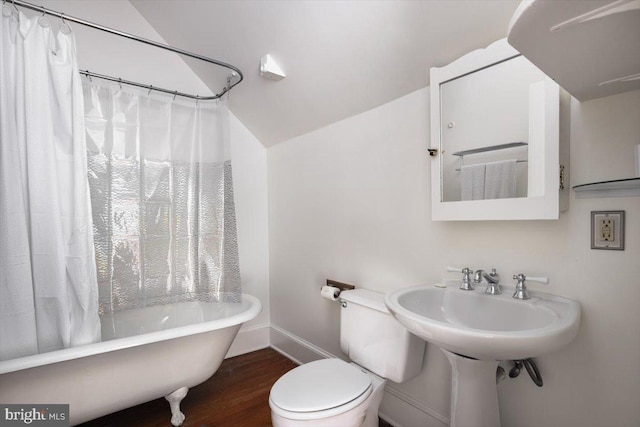 bathroom featuring hardwood / wood-style flooring, toilet, vaulted ceiling, and shower / bath combo