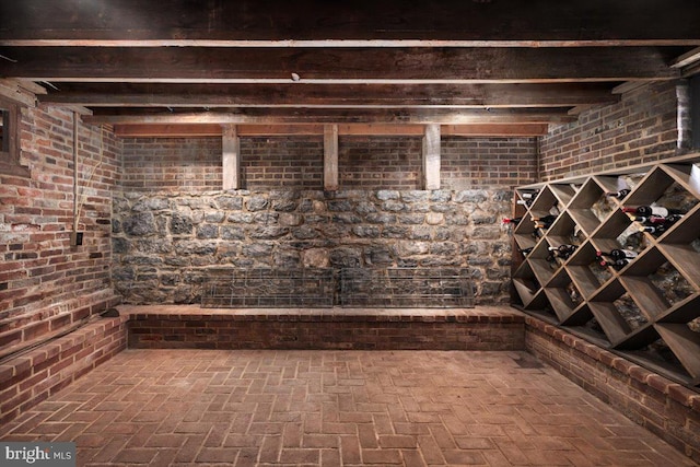 wine room featuring beamed ceiling