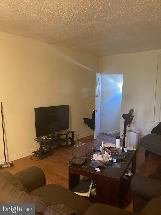 living room with hardwood / wood-style floors and a textured ceiling