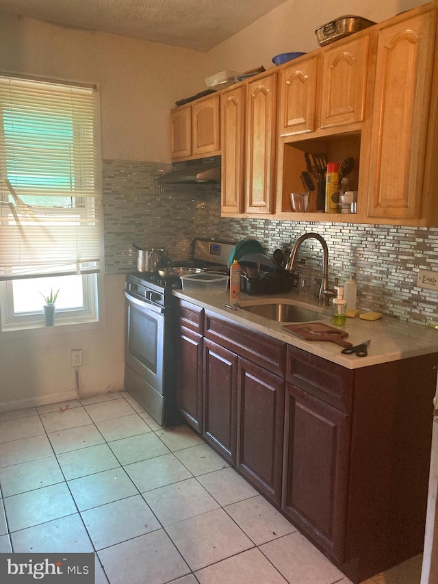 kitchen with light tile patterned floors, backsplash, electric range, and sink