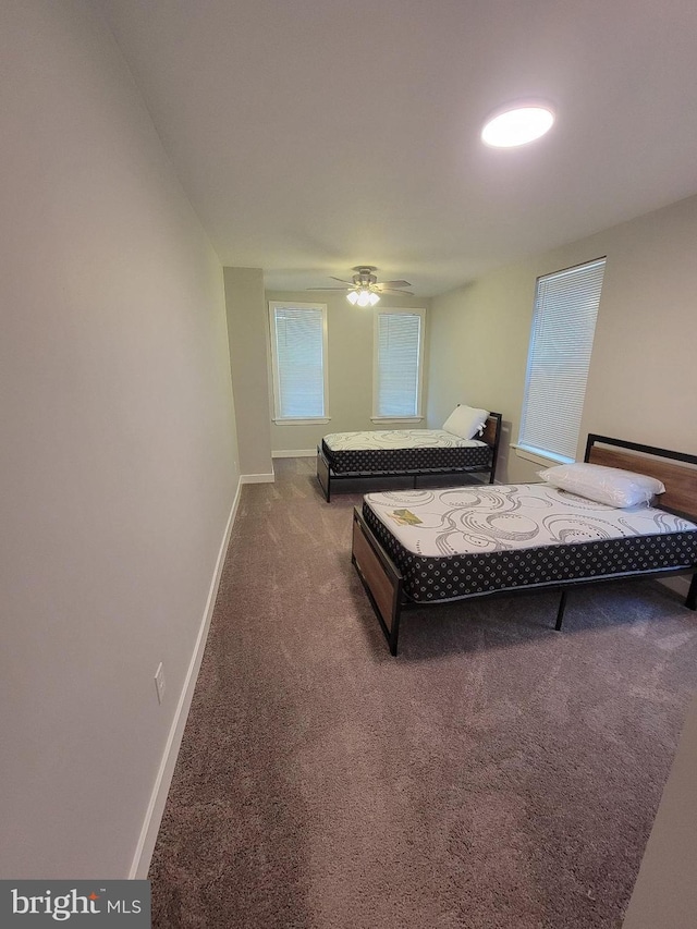 bedroom featuring ceiling fan and dark carpet