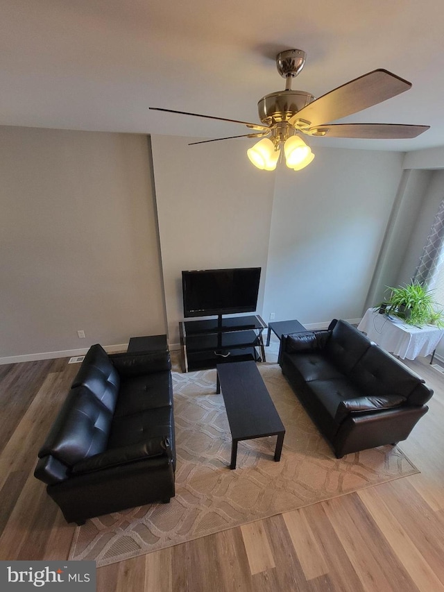 living room with light hardwood / wood-style floors and ceiling fan