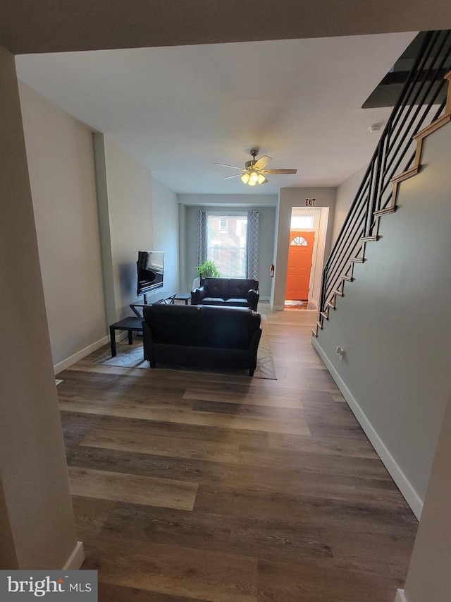 living room with ceiling fan and dark wood-type flooring