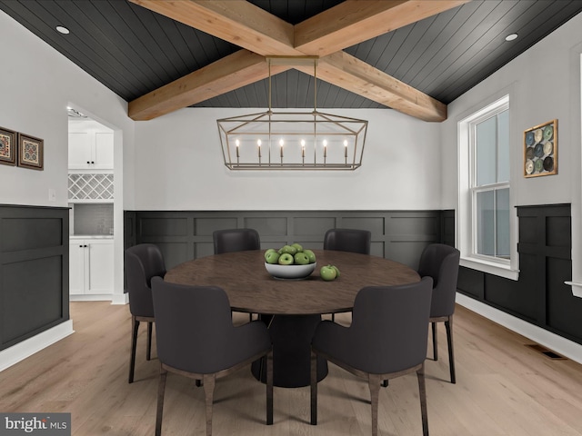 dining area featuring a chandelier, light wood-type flooring, lofted ceiling with beams, and wood ceiling