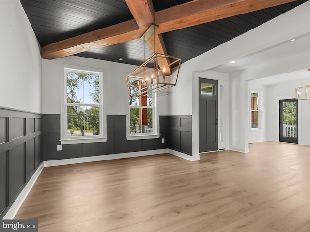 interior space with lofted ceiling with beams, light hardwood / wood-style flooring, a chandelier, and wooden ceiling