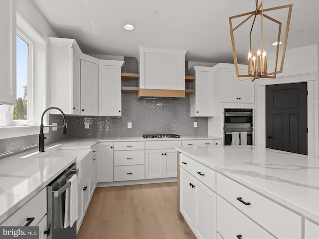 kitchen with white cabinets, a chandelier, and stainless steel appliances