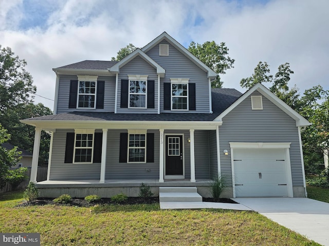 view of front of home with a front lawn, covered porch, and a garage