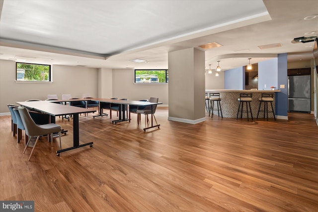 recreation room with bar and hardwood / wood-style flooring