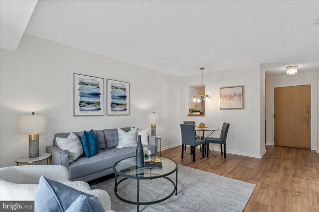 living room with a chandelier and light hardwood / wood-style floors