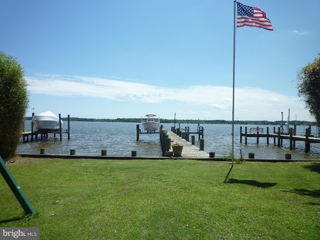 dock area with a yard and a water view