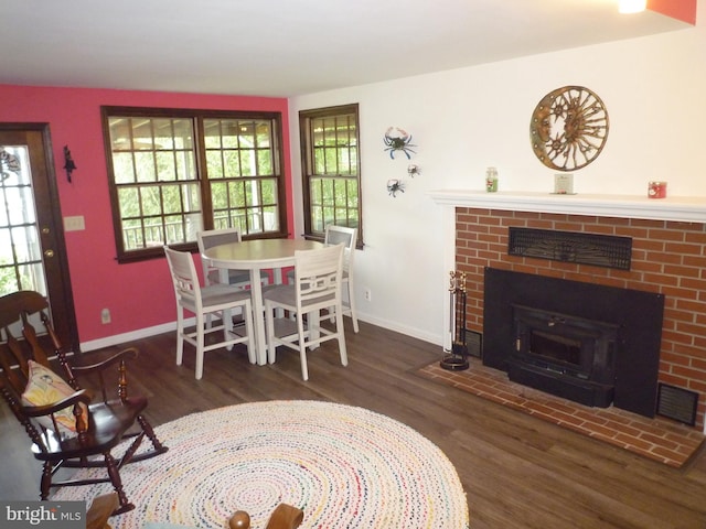 dining space featuring a fireplace and dark hardwood / wood-style flooring