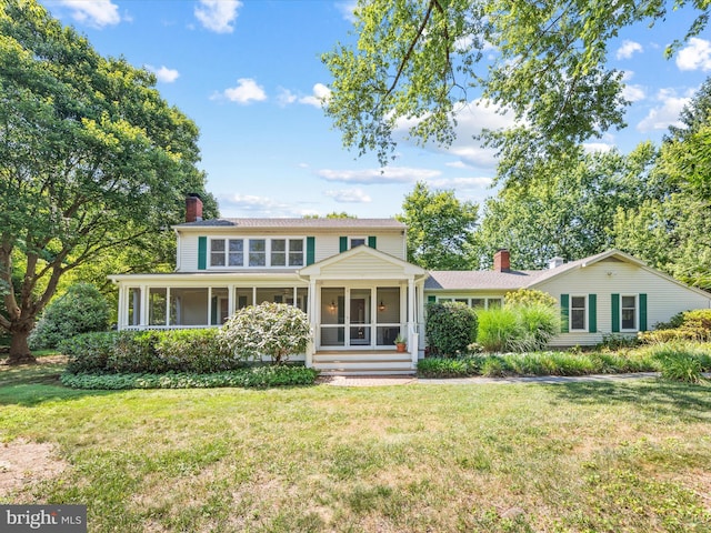 view of front of property featuring a sunroom and a front yard