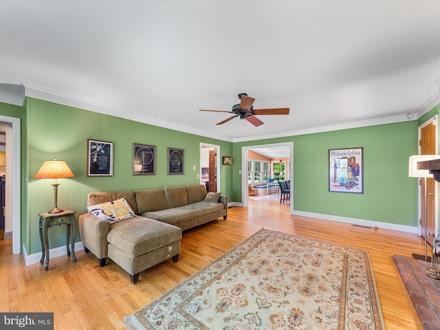 living room with ceiling fan, ornamental molding, and hardwood / wood-style flooring