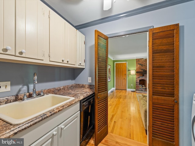 kitchen featuring crown molding, sink, white cabinetry, and black dishwasher