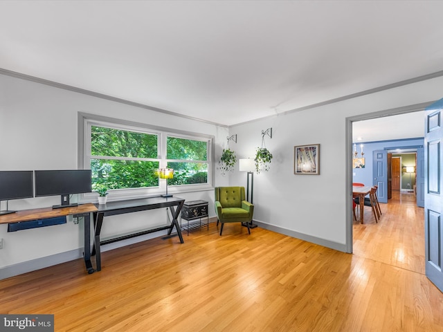 sitting room with light wood-type flooring and ornamental molding