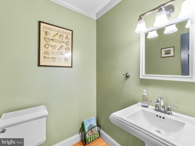 bathroom with toilet, sink, wood-type flooring, and crown molding