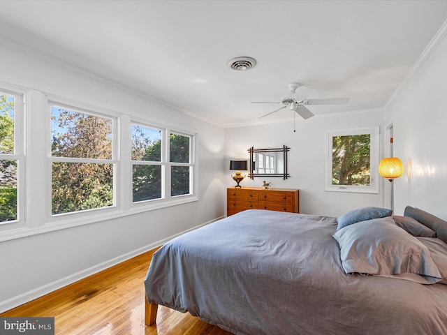 bedroom featuring ceiling fan, wood-type flooring, and ornamental molding