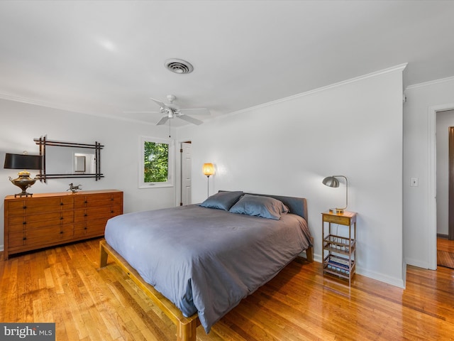 bedroom with ceiling fan, crown molding, and light wood-type flooring