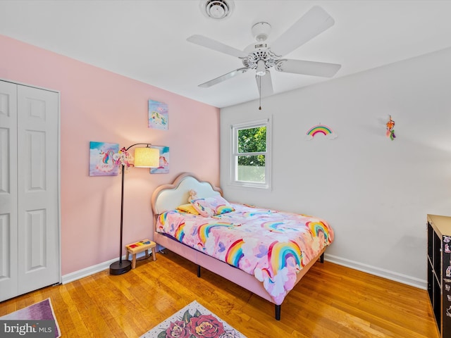 bedroom featuring hardwood / wood-style floors, ceiling fan, and a closet