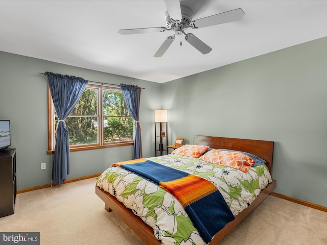 bedroom with ceiling fan and light carpet