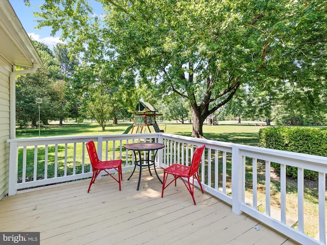 wooden deck with a yard and a playground