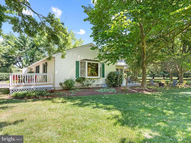 view of side of property featuring a lawn and a wooden deck