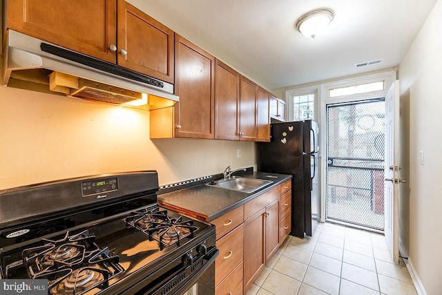 kitchen with sink, light tile patterned flooring, and black appliances