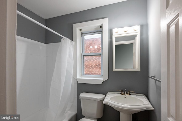 bathroom featuring sink, toilet, and walk in shower