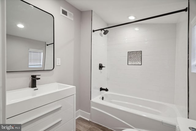 full bathroom featuring tiled shower / bath, toilet, wood-type flooring, and vanity