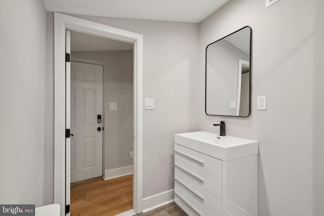 bathroom featuring lofted ceiling, vanity, and hardwood / wood-style flooring